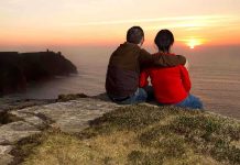 Doctor Dragged Wife Toward 700-Foot Drop A couple sitting on a cliff watching the sunset over the ocean