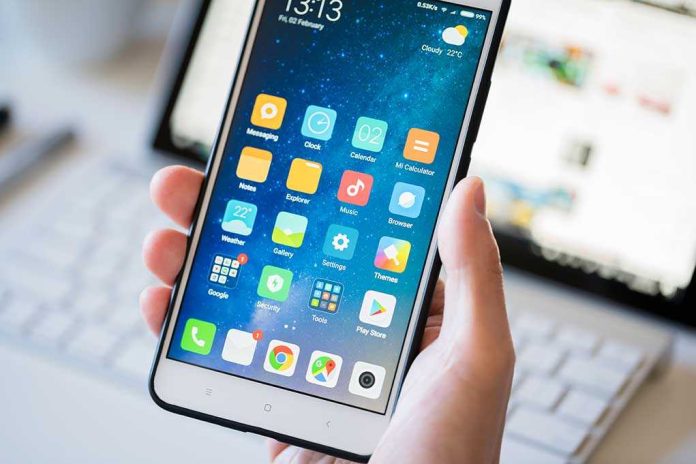 A person holding a smartphone displaying various mobile applications