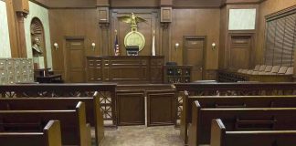 Serial Killer’s Bold Innocence Plea Falls Flat Interior view of an empty courtroom with wooden benches and a judges bench