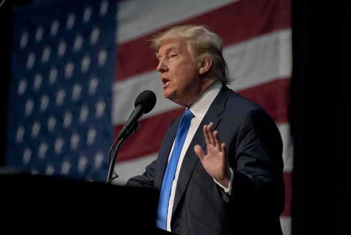 man in suit speaking at a podium with a US flag backdrop