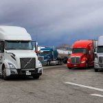 Foreign Truckers Purged — Veterans Step In Semi trucks parked at a rest area under cloudy sky