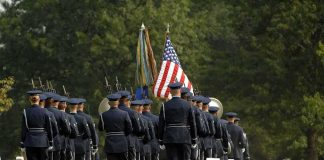 84 Years Later, WW2 Soldier Comes Home Military honor guard marches through a cemetery with flags