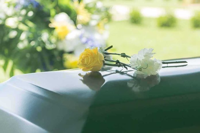 Yellow rose and white carnation on a green casket