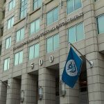U.S. government building facade with American and blue departmental flags