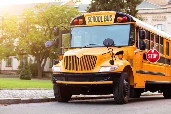 shutterstock_2376174803 Yellow school bus with stop sign extended