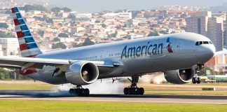 airliner landing on runway with smoke from tires