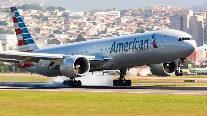 shutterstock_693382546 airliner landing on runway with smoke from tires