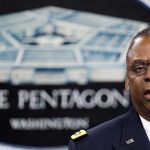 Hegseth GRILLED After $1.5 Trillion Request Lloyd Austin speaking at a podium in front of a Pentagon emblem