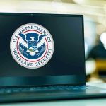 Airline Quietly Implements NEW BAN For All Flights! Laptop displaying U.S. Department of Homeland Security logo.