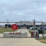 Small Cages Found Outside ICE Detention Center Chain-link fence with Restricted Area Stop No Photography sign.