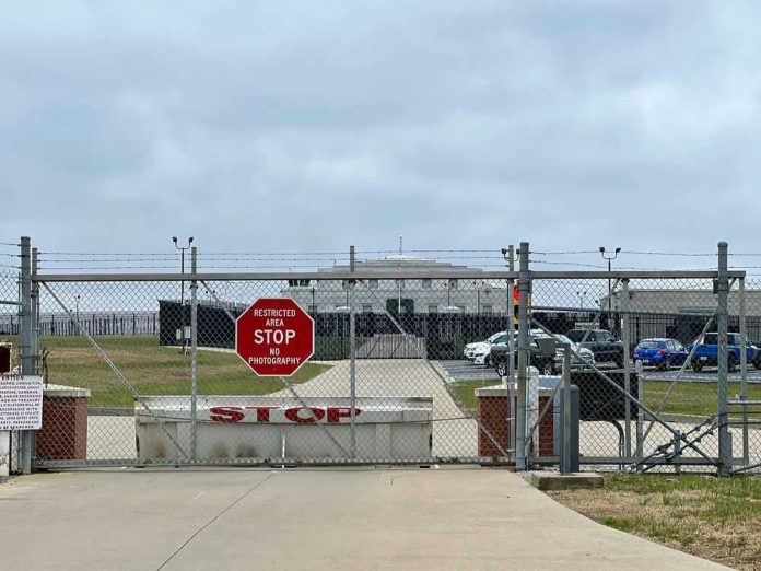 2375002113 Chain-link fence with Restricted Area Stop No Photography sign.