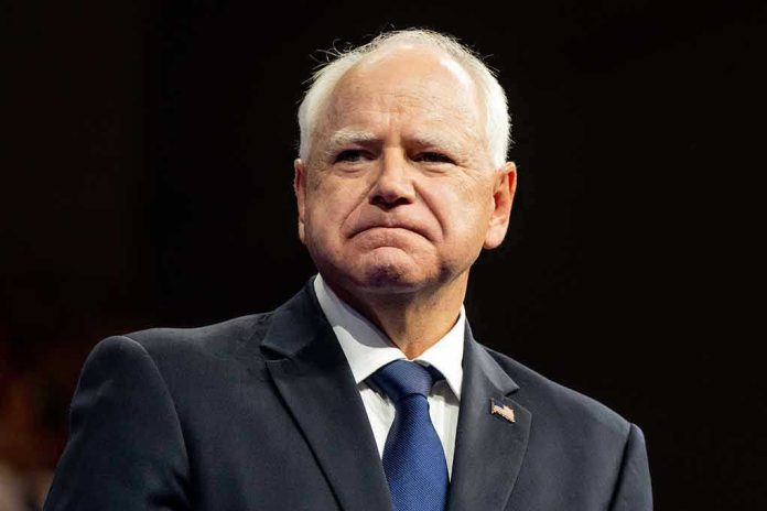 Tim Walz in a dark suit and tie at an event