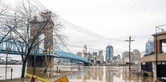 Flooded riverfront with bridge and city skyline