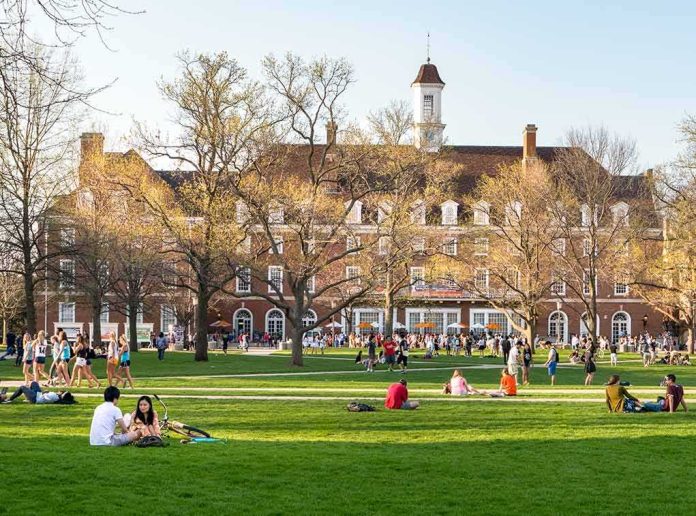 Students relaxing on a campus quad in front of a brick academic building