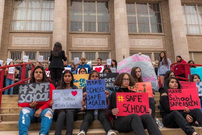 Students holding protest signs on school steps