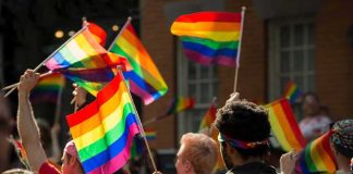 162 LQBTQ Arrested in Midnight Raid Crowd waving rainbow flags at an outdoor event