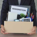 Person holding a cardboard box of office belongings