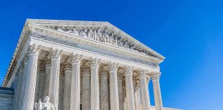 Supreme Court Greenlights Voter Check Tool Supreme Court building with tall marble columns under a clear blue sky