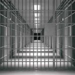 empty prison corridor with barred cells