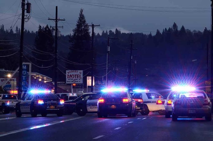 Police cars with flashing lights block a road at night