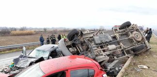 Overturned truck and damaged cars after highway crash