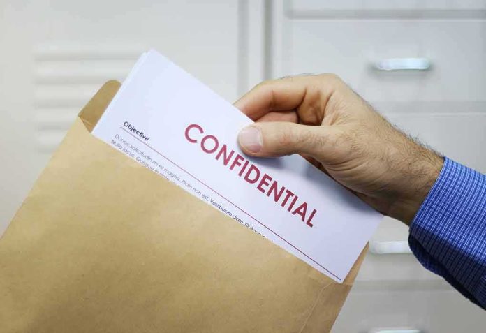 Hand placing confidential document into a brown envelope