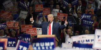 Donald Trump speaks at a rally, giving two thumbs up