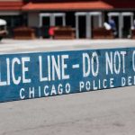 Police barricade with 'Do Not Cross' message in urban street