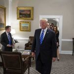 Donald Trump walks through an office with Sean Lawler nearby and Mariano Rajoy following behind
