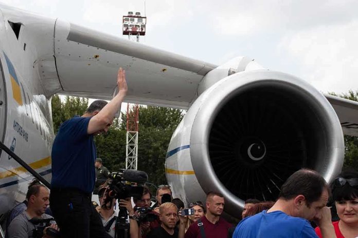Group of people gathered near a large airplane engine