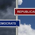 Directional signs for two political parties on a pole