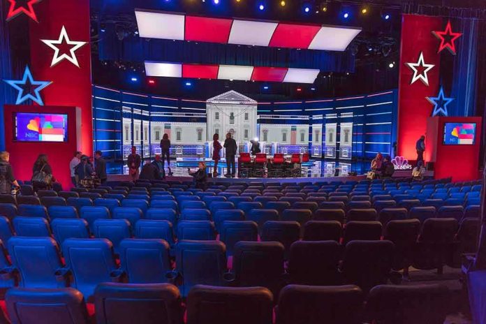 shutterstock_1656995731-1 Debate stage with red and blue lighting and empty audience seats