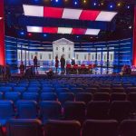 Senator Torches Disgraced Democrat On CNN! Debate stage with red and blue lighting and empty audience seats