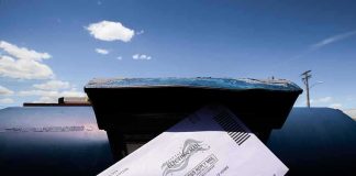 Ballots Dumped In Church Dumpster Mail-in ballot being inserted into a blue USPS mailbox