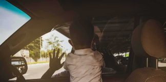 Child leaning on car window from the back seat