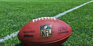 American football on a turf field near a white yard line