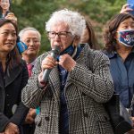 Như Quỳnh and Grace Meng at an outdoor rally with a speaker holding a microphone
