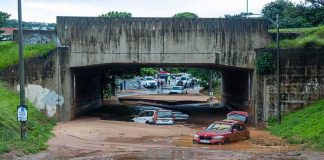 Flooded underpass with stranded cars in muddy water