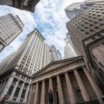 Skyscrapers and a neoclassical building with columns viewed from street level
