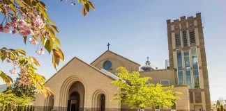 After 156-Years Beloved Church Razed To The Ground Brick church with arched entrance and tall bell tower on a sunny day