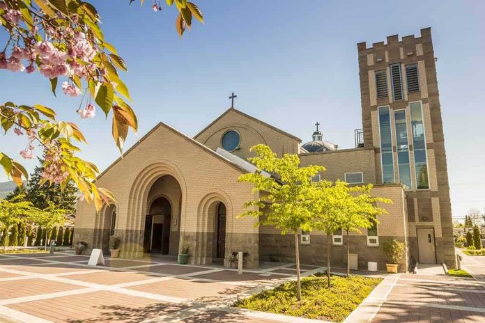 shutterstock_264314027 Brick church with arched entrance and tall bell tower on a sunny day