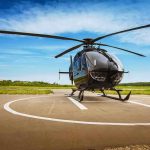 Black helicopter on a helipad