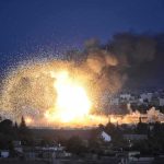 Large explosion over a city at night