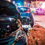 Wrecked cars at night crash scene with police lights
