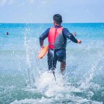 GRUESOME Shark Attack Turns Beach Red! lifeguard wading into ocean with rescue buoy