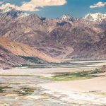 Mountain valley with river and snow-capped peaks