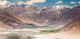 Mountain valley with river and snow-capped peaks