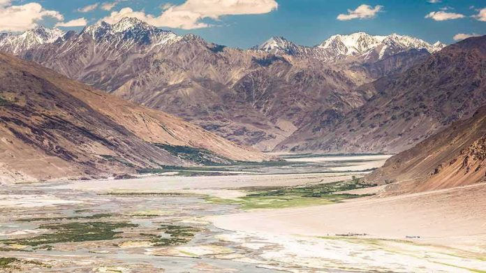 shutterstock_757509412 Mountain valley with river and snow-capped peaks