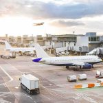 Dem Socialists Target Airport Workers to Block Israeli Cargo Airplanes at airport gates during sunset with ground vehicles and jet bridges