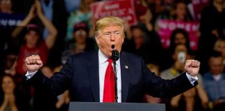 Trump Calls Somalia a ‘SH*T House’ During Rant Donald Trump speaking at a rally podium with arms raised